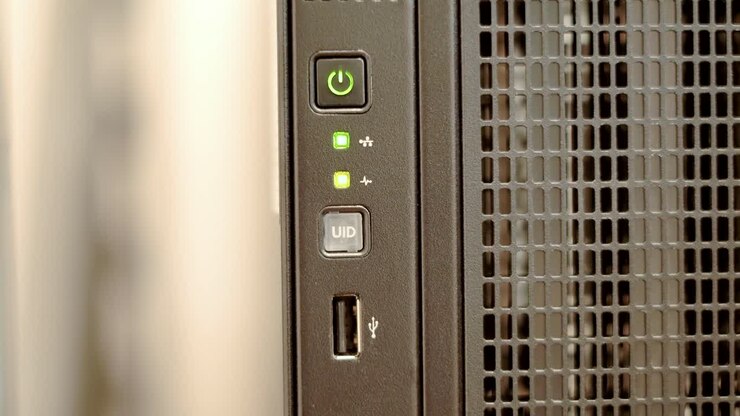 A green network indicator light blinks sporadically on a black tower server