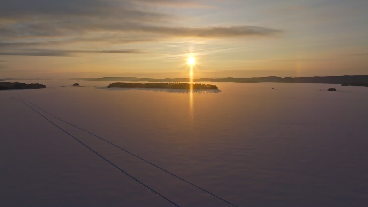 Aerial view rising over lake Pielinen, winter sunrise in North Karelia, Finland