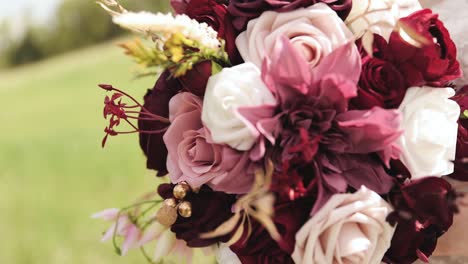 primer plano de la novia con su vestido de novia al aire libre sosteniendo un ramo de flores rosadas, moradas y blancas 1080p 60 fps