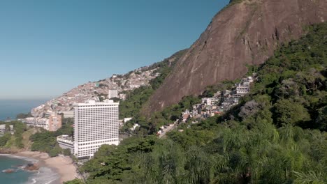 toma aérea ascendente recta desde un estacionamiento con palmeras y revelando la montaña de los dos hermanos y la playa vidigal en río de janeiro