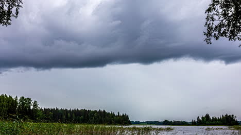 Timelapse-De-Nubes-Nimboestratos-Que-Envuelven-Y-Se-Desplazan-Por-El-Cielo-Sobre-Un-Lago-Rural