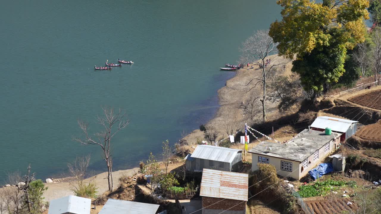 una vista de ángulo alto de algunos pequeños barcos de remo en el lago kulekhani en nepal tomando turistas en un recorrido por el lago