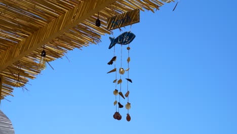 Decoración-De-La-Vida-En-La-Playa-Con-Conchas-Marinas-En-El-Techo-De-Paja-Del-Bar-Con-Fondo-De-Cielo-Azul-Claro