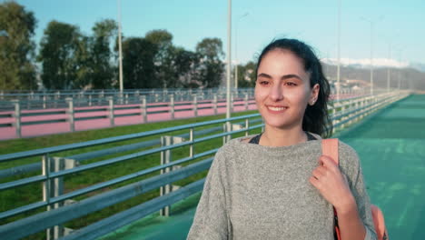 mujer sonriente caminando por un puente