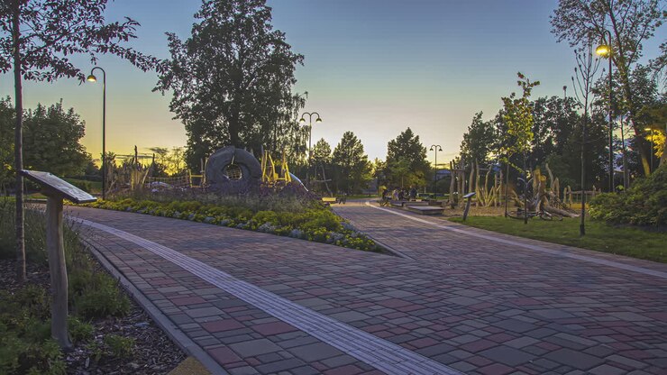 Static shot of a two way pathway among the trees and flower with fresh air in the public tropical garden during evening in timelapse