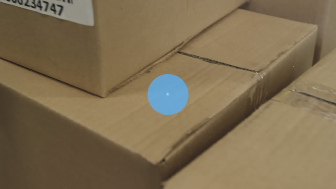 Animation of connected speedometer and lock over cardboard boxes with barcodes in warehouse