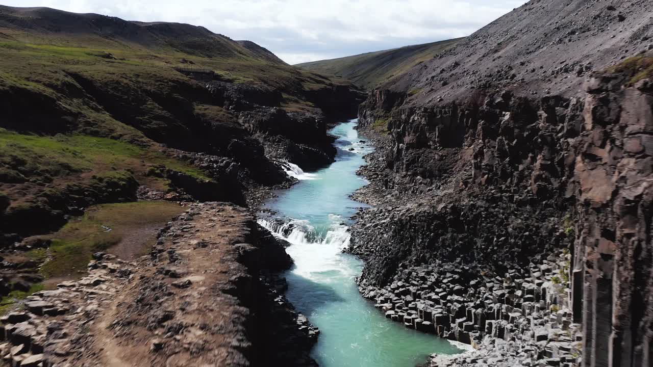 Blue mineral high water in Studlagil gorge of Iceland, aerial