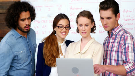 Business-executives-discussing-over-laptop-in-meeting