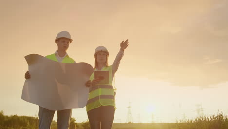 Ingeniero-Y-Supervisor-Con-Tableta-Y-Los-Dibujos-Tratan-Sobre-Líneas-Y-Torres-De-Transmisión-Y-Discuten-El-Plan-De-Expansión-Y-La-Energía-De-Transporte-Para-Pueblos-Y-Ciudades.