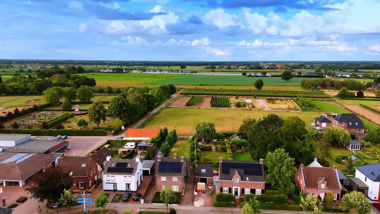 Campi e case in campagna. Campi verdeggianti e rigogliosi circondano un incantevole quartiere con case sotto un cielo blu brillante, mettendo in mostra la vita rurale