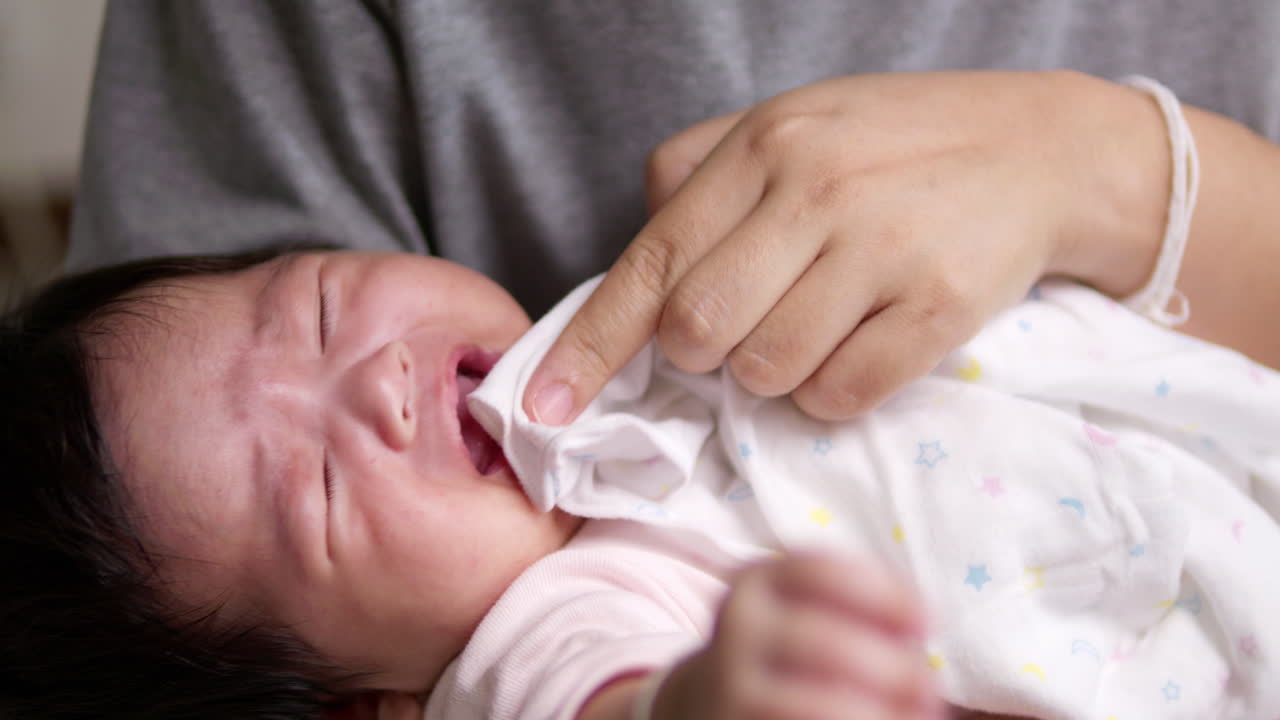 울고 있는 신생아를 안고 돌보는 것