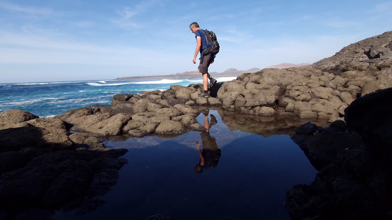 senderismo en la costa de lanzarote en los acantilados al mar con reflejos en la piscina