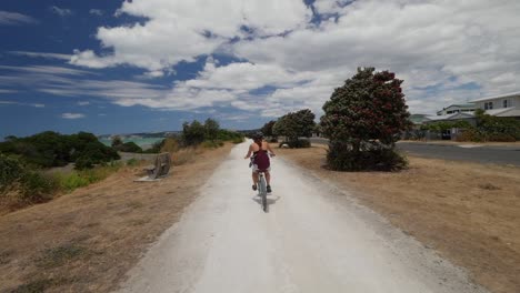 Schönes-Mädchen,-Das-Mit-Dem-Fahrrad-Einen-Strandweg-Entlang-Fährt