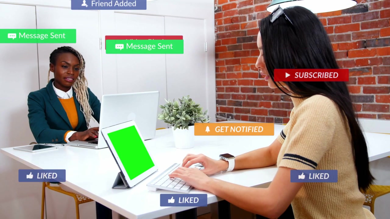 Colleghi che digitano al tavolo, l'input dal tablet avvia degli overlay che mostrano un'attività sociale in crescita e poi in calo.