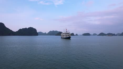 antena de un hermoso crucero blanco en la bahía de ha long vietnam al atardecer que rodea las aguas tropicales