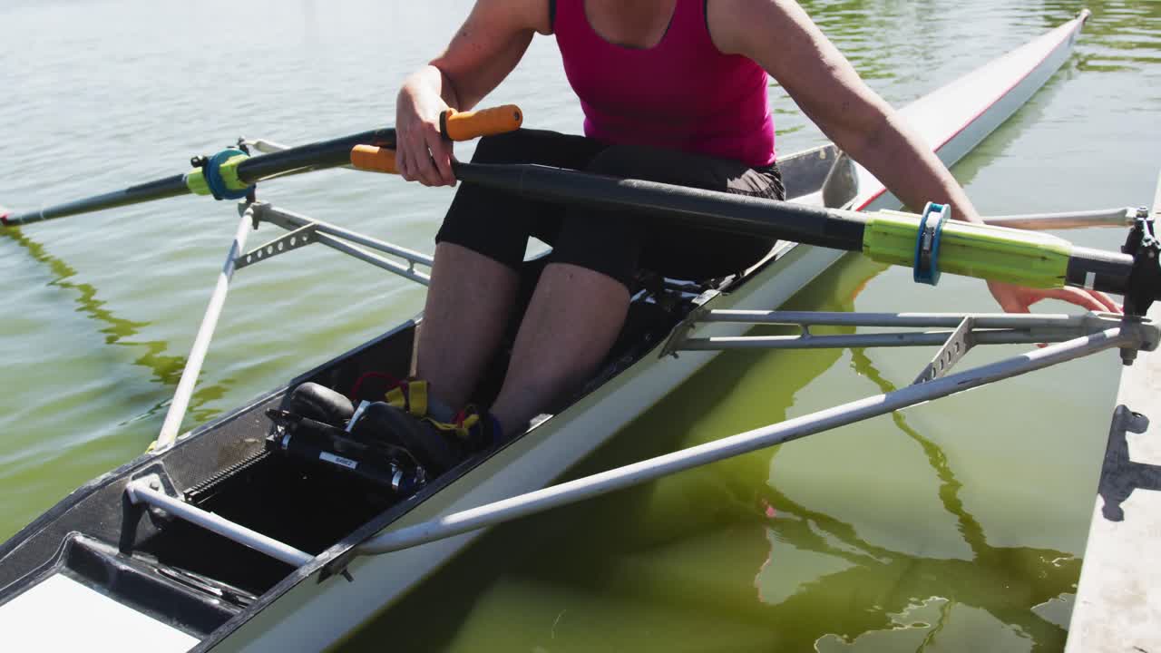 Senior caucasian woman preparing rowing boat in a river