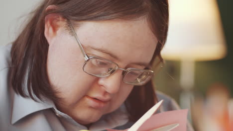 person with down syndrome making a card