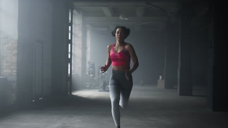 woman running fast in crossfit gym. female athlete jogging in sport club