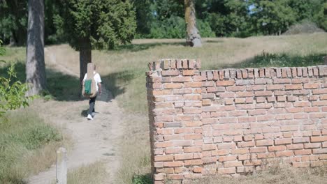 joven caminando con la guitarra en la calle cerca del bosque