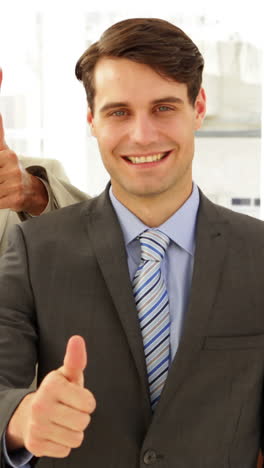 business team giving thumbs up to camera