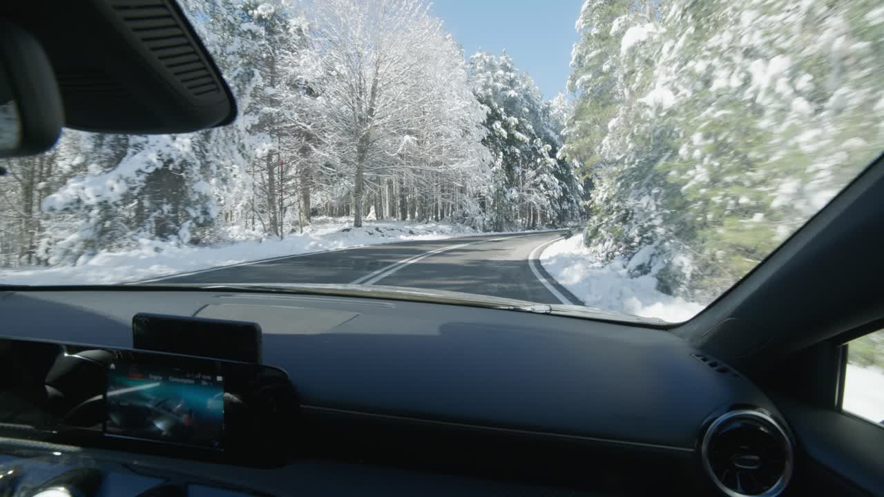 pov asiento de pasajero conduciendo un coche deportivo caro a través de carreteras de montaña cubiertas de nieve invierno día soleado