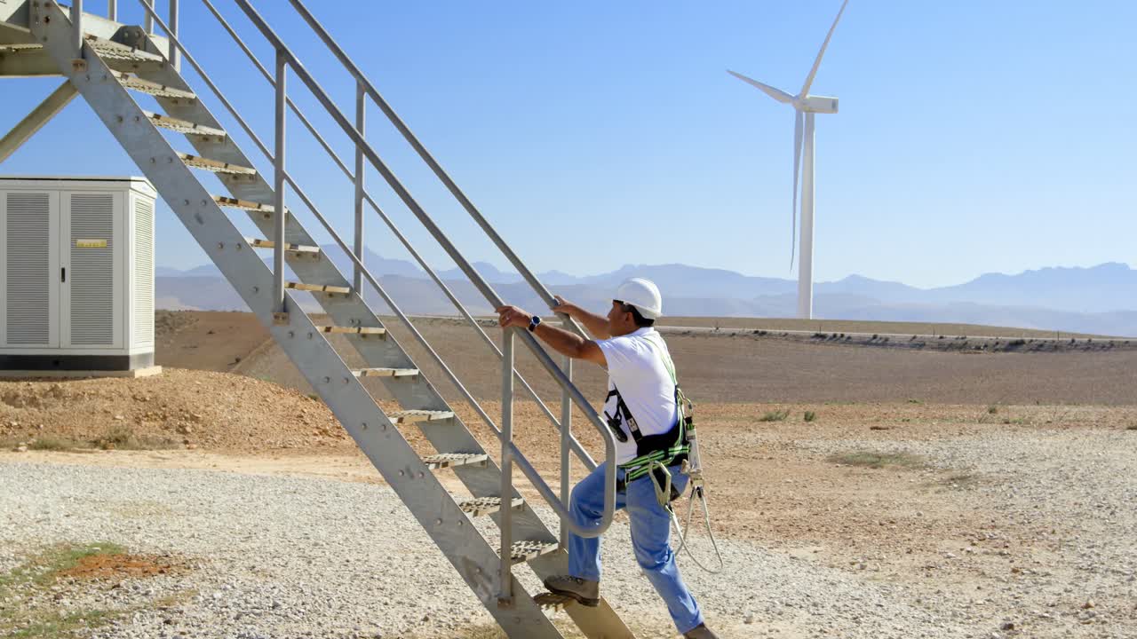 ingeniero masculino caminando por las escaleras en el parque eólico 4k
