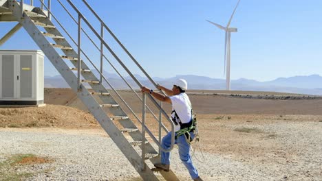 Male-engineer-walking-upstairs-in-the-wind-farm-4k