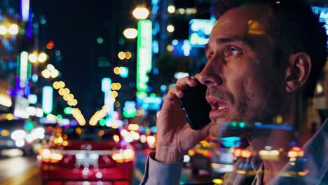 man talking on phone in night city