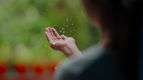 child’s hands reaching out in rain, droplets landing gently on palms, serene rural weather scene, 4k video