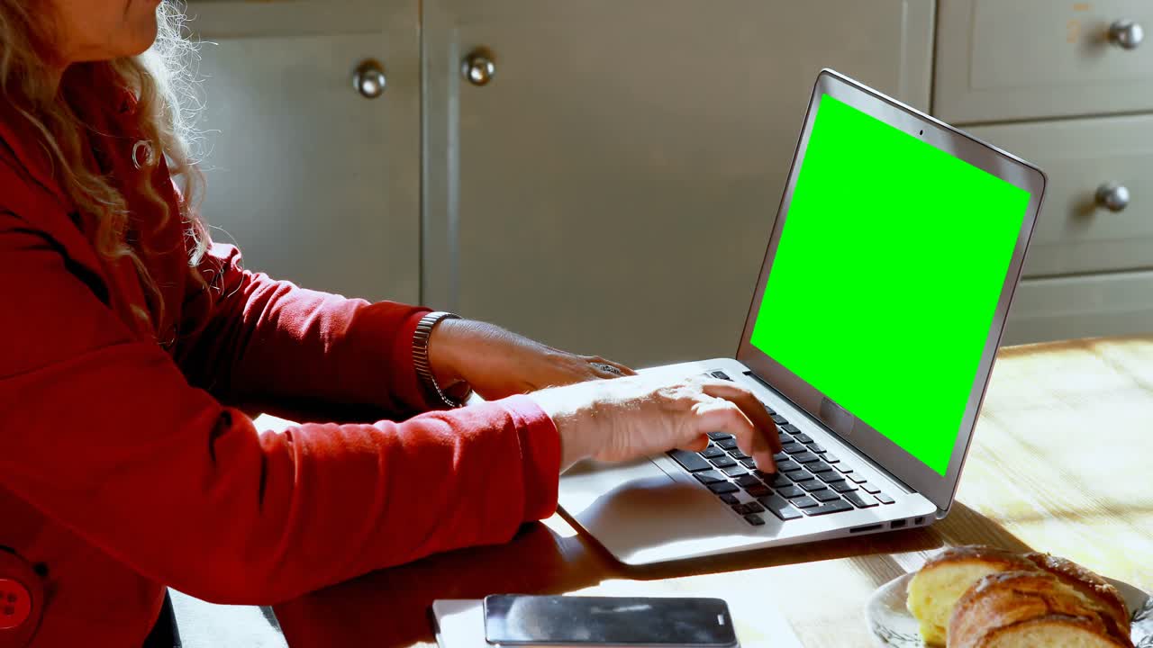 Mature woman using laptop at home 4k
