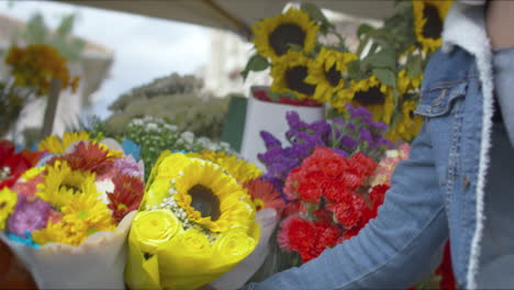 chico guapo comprando flores en la calle