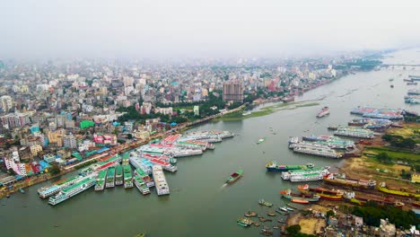 aerial view of dhaka city skyline with boats waiting for repair in the buriganga river, bangladesh
