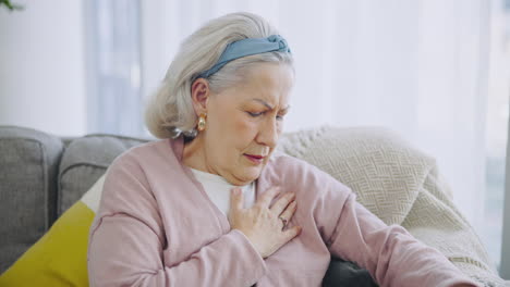 Senior-woman,-chest-pain-and-sofa-in-home