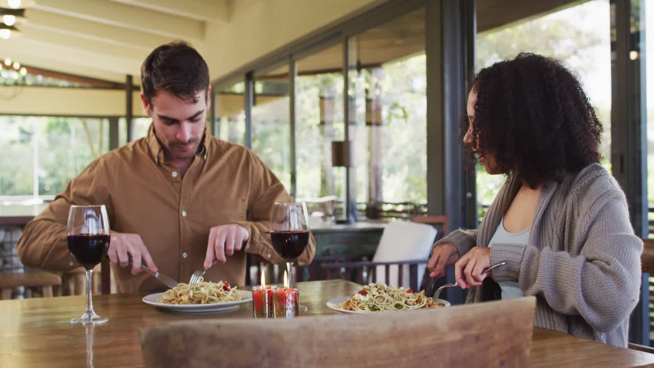 Coppia mista felice che pranza insieme al ristorante.