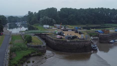 Luftaufnahme-Spike-Island-Council-Arbeiter-Entfernen-Auferstehungskonzertbarrieren-Vom-River-Canal-Park-Unten-Rechts-Dolly