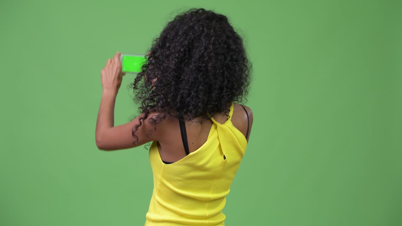 Young beautiful Hispanic woman photographing with phone