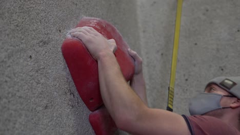 rock climber climbing an indoor rock wall using athletic chalk for grip-2