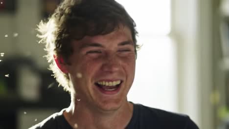 young man enjoying a moment of laughter in a bright indoor setting with soft lighting