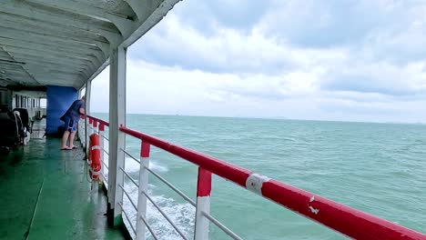 a ferry glides through turquoise waters under cloudy skies near koh samui, thailand, capturing serene ocean views and distant islands