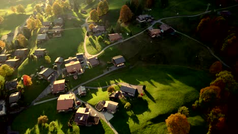 aerial-drone-footage-pushing-in-over-Grindelwald-village,-spectacular-fall-colors-at-sunset