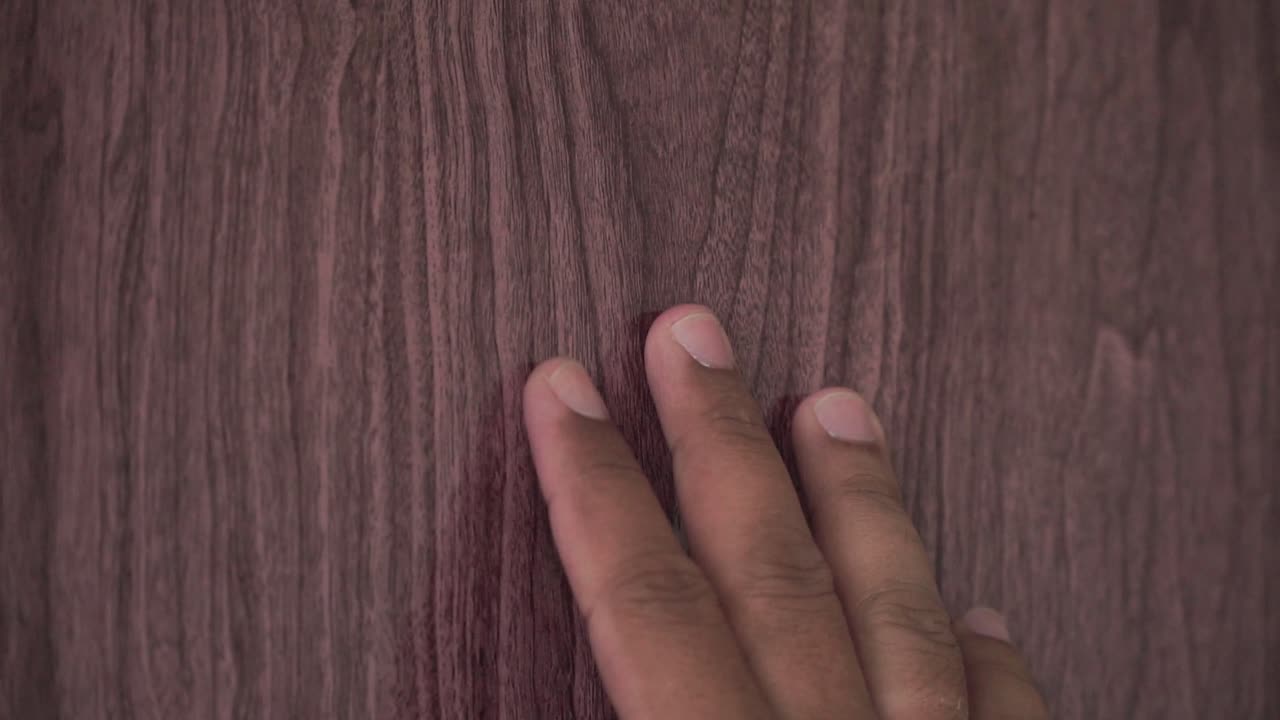 A human hand touched the surface of the wooden door