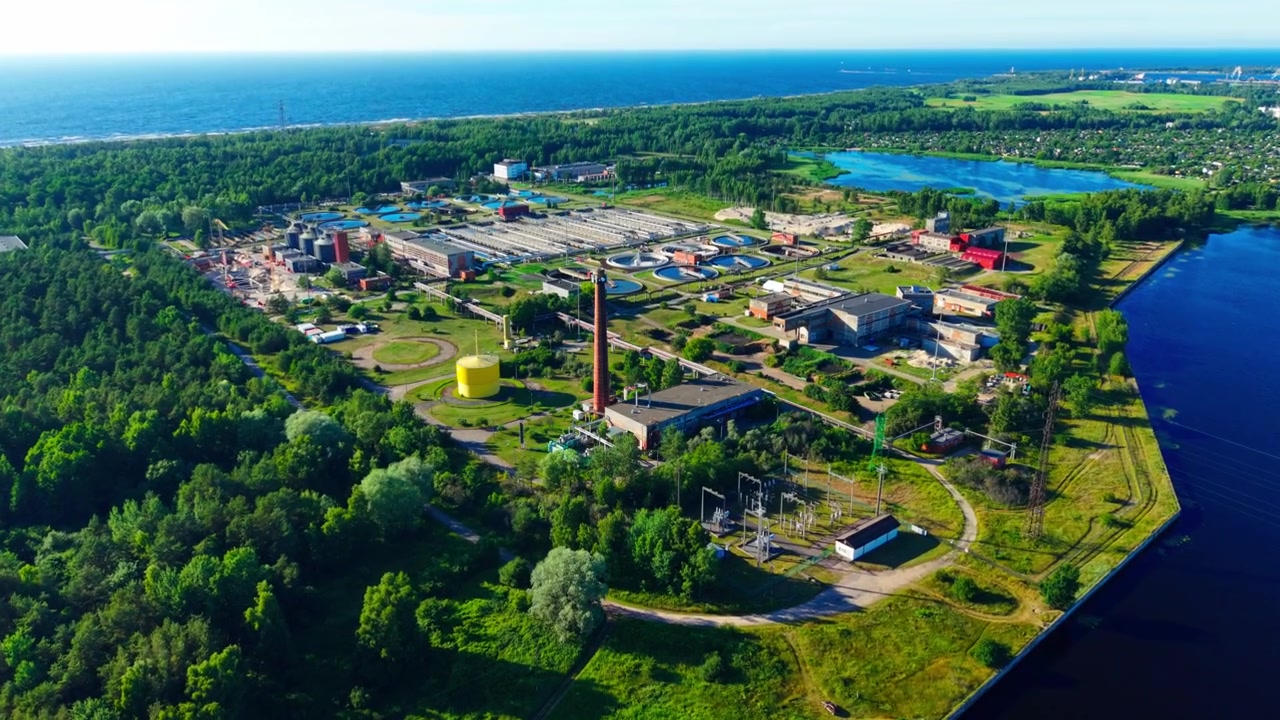 Drone flies forward with tilt down revealing Riga wastewater treatment plant