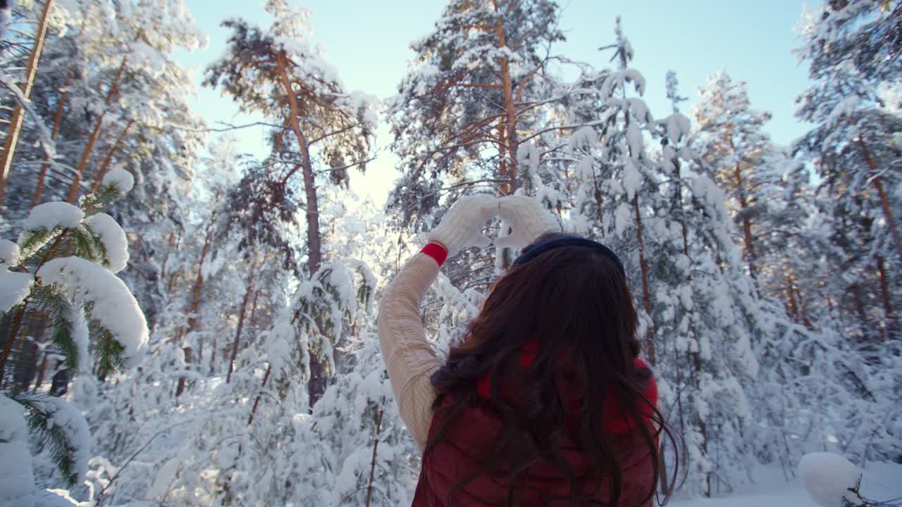 Woman taking a photo in a snowy forest