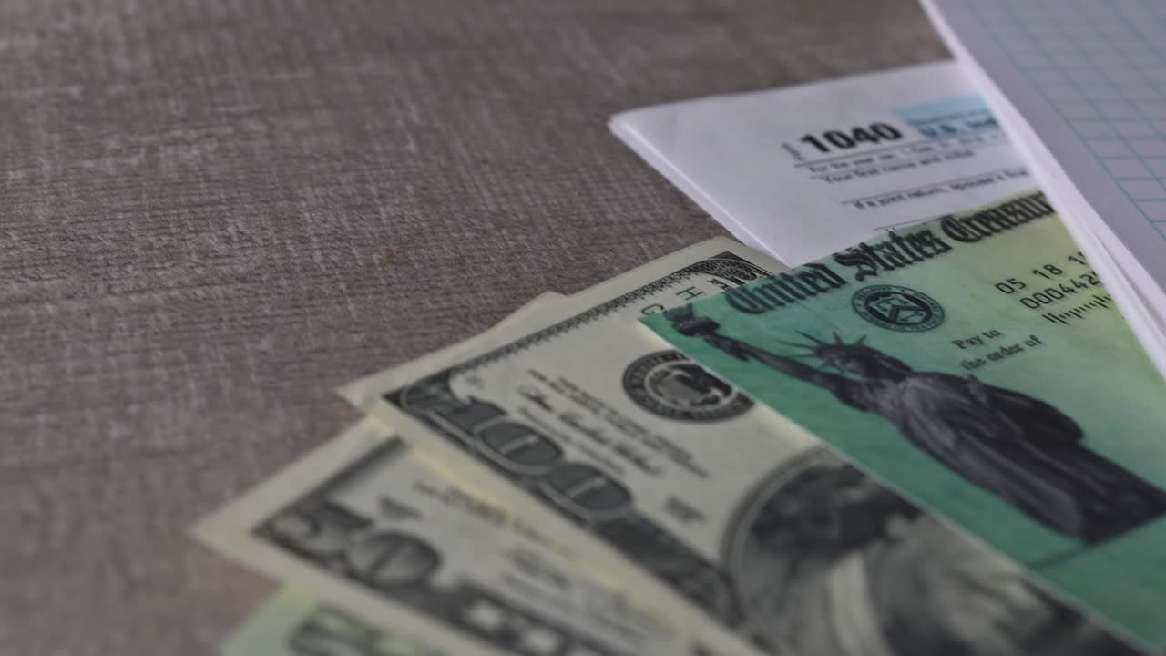 1040 Modulo fiscale con assegno di rimborso e valuta Primo piano delle banconote in dollari USA