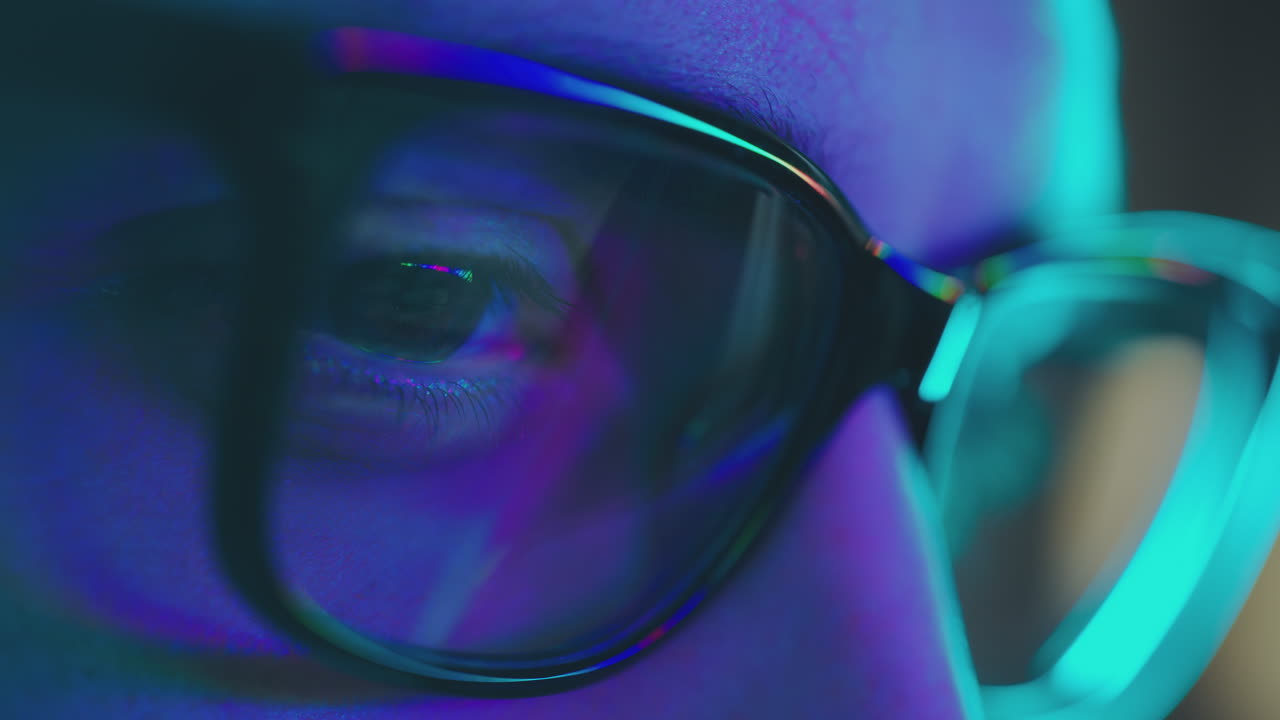 Close-up of person wearing glasses in blue light