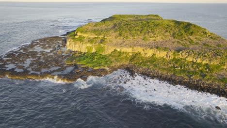 waves breaking in the rocky coast of cook island on a sunny day in new south wales, australia