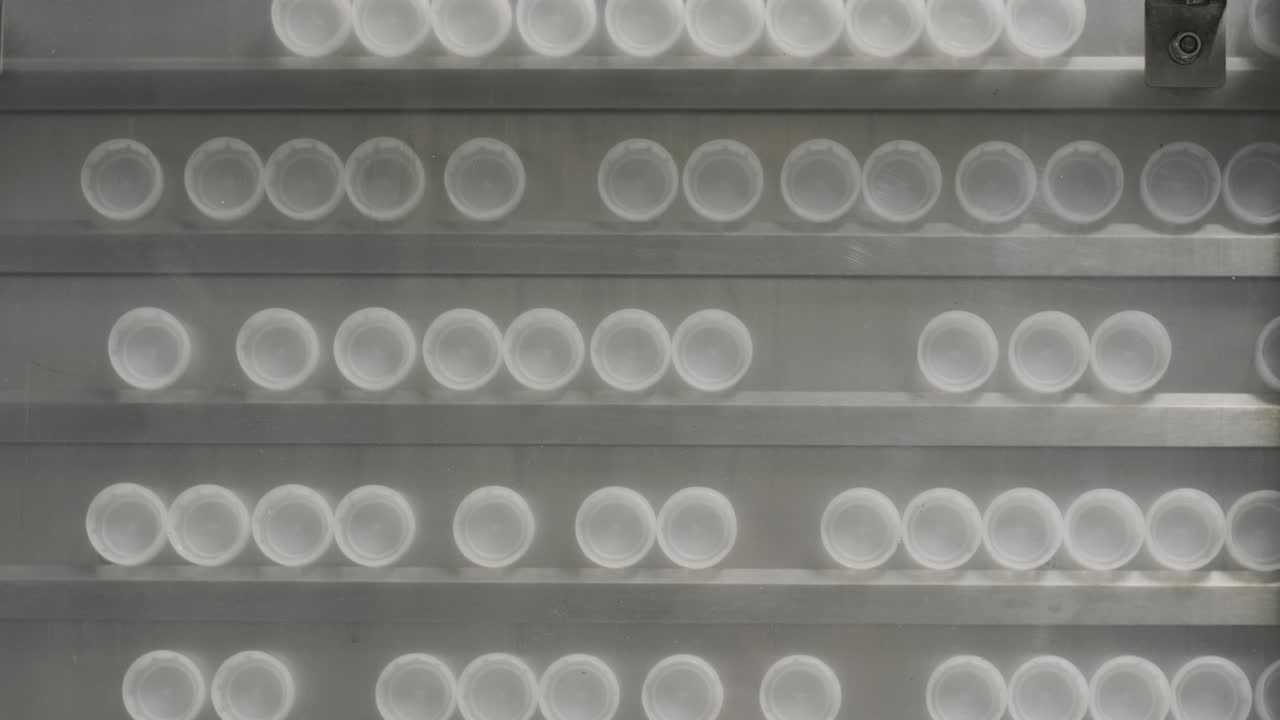 автоматическая машина для наполнения наливает воду в пластиковые бутылки на современном заводе по производству напитков