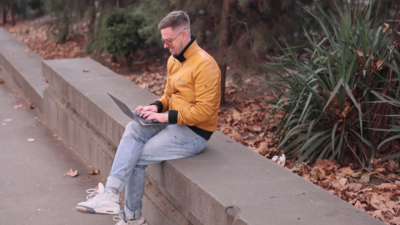 Man working on laptop in the park