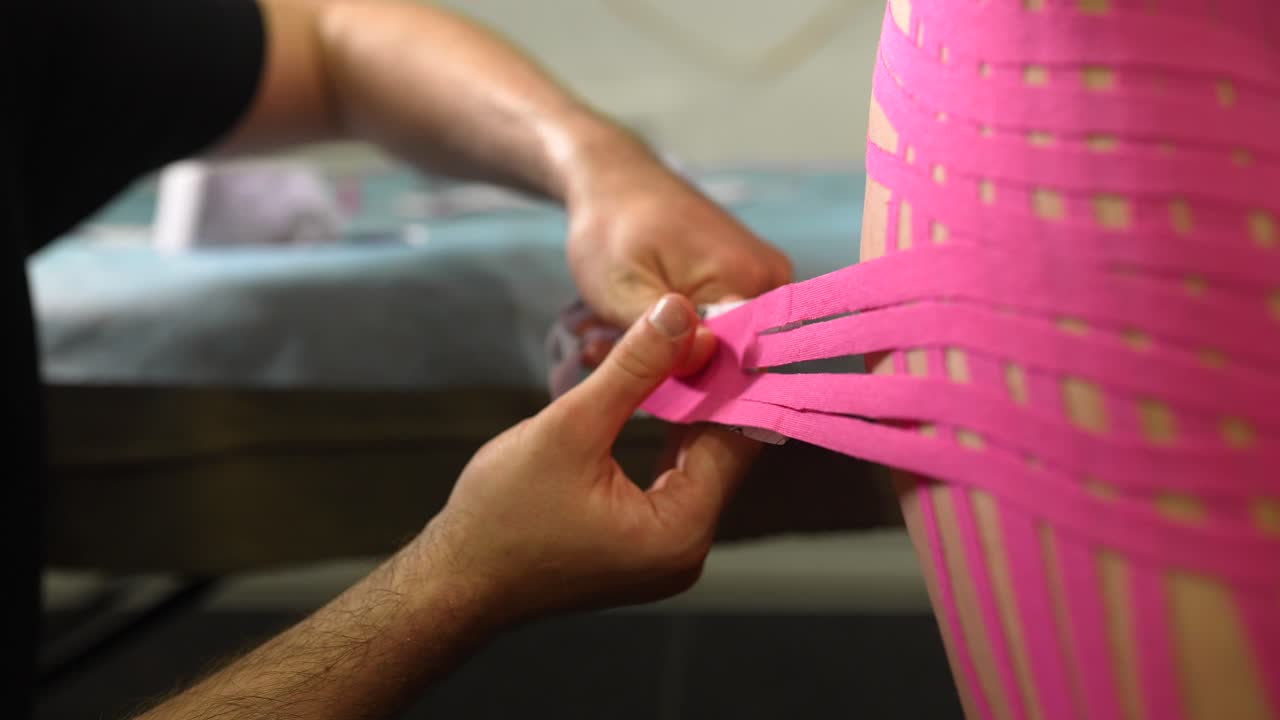 Aplicando cinta de kinesiología en la espalda
