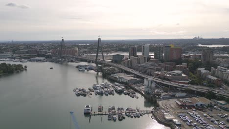 Vista-Aérea-Del-Puente-Anzac-Y-El-Tráfico-De-Automóviles-Sobre-El-Puerto-Deportivo-En-El-Puerto-De-Sydney-Al-Atardecer